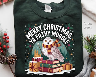 May include: Forest green sweatshirt with the text "MERRY CHRISTMAS YA FILTHY MUGGLE" and a graphic of an owl wearing a scarf and holding a wand. The owl is perched on a stack of books and presents. A castle is in the background.