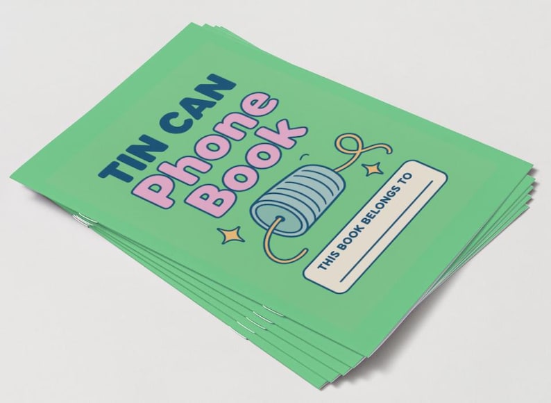 May include: A stack of green notebooks with the words "TIN CAN Phone Book" in blue and pink. The cover features a cartoon tin can phone illustration and the text "THIS BOOK BELONGS TO".