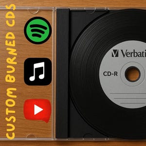Puede incluir: Un disco CD-R negro en una funda de plástico transparente, con el texto "Verbatim" y "CD-R" impreso en el disco. La funda está sobre una superficie de madera, con las palabras "CUSTOM BURNED CDS" y logotipos de servicios de transmisión de música.