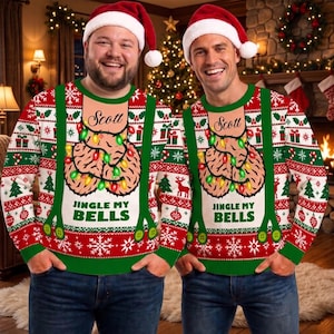 May include: A long-sleeve crewneck jumper featuring a red, white, and green holiday pattern with snowflakes, candy canes, and trees. The centre graphic shows a pair of testicles wrapped in Christmas lights with the text "Scott" and "JINGLE MY BELLS".