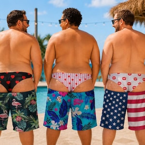 K&ouml;nnte beinhalten: Drei Badehosen mit verschiedenen Mustern: eine schwarze mit rosa Flamingos, eine blaue mit tropischen Blumen und eine mit amerikanischem Flaggendesign. Jede Badehose wird mit einer passend gemusterten Unterhose darunter getragen.