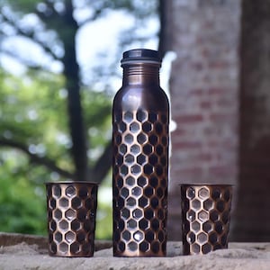 Handmade pure copper water bottle with honeycomb design and matching tumblers, eco-friendly and perfect for gifting.