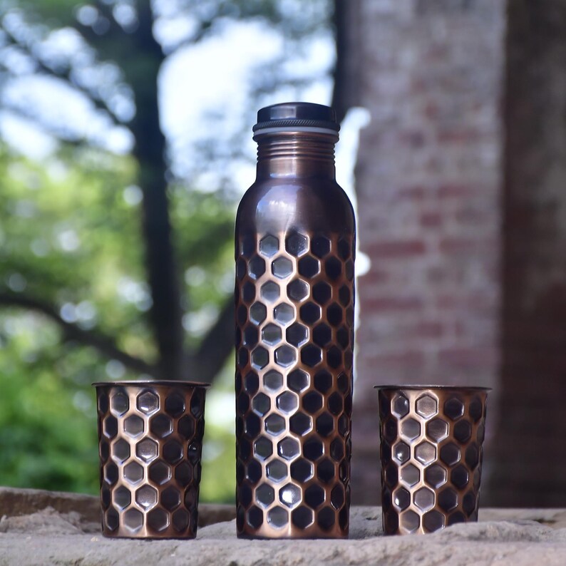 Handmade pure copper water bottle with honeycomb design and matching tumblers, eco-friendly and perfect for gifting.