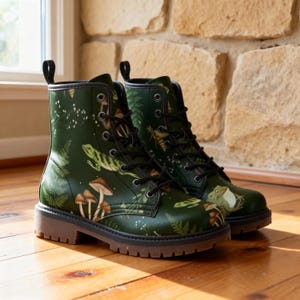 May include: Green combat boots with a nature-themed design featuring mushrooms, ferns, and frogs. The boots have black laces, a brown sole, and a pull tab. The boots are a stylish footwear option.