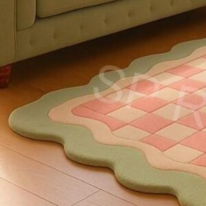 Pastel tufted rug with scalloped border and geometric pattern