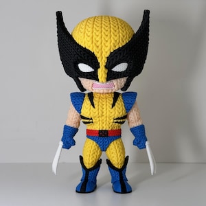 May include: A knitted Wolverine figure in yellow, blue, black, and white. The figure has a yellow head with black mask and ears, blue gloves and boots, and two silver claws. The figure is wearing a yellow and blue costume with a red belt.
