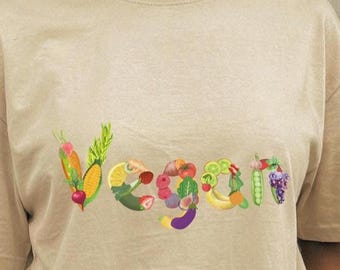 Vegan spelled in fruit and veggies on this tee shirt. Short sleeved 100% cotton classic unisex T-shirt. Colorful sustainable art clothing.