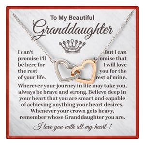 May include: A silver necklace with two interlocking heart pendants, one silver and one gold. The card reads "To My Beautiful Granddaughter" with a message of love and support.