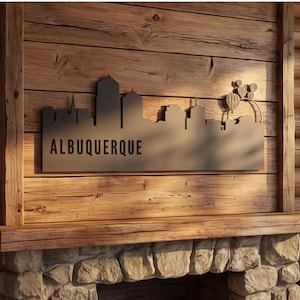 May include: A metal wall art piece featuring the Albuquerque skyline silhouette. The artwork is mounted on a wooden wall above a stone fireplace. The word "ALBUQUERQUE" is displayed below the skyline.