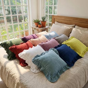 May include: A white ceramic mug with a black handle and the text "But First, Coffee" in a bold, black font. The mug is set against a blurred background, suggesting a cozy setting.