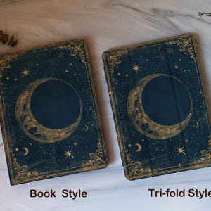 May include: Two dark blue book-style and tri-fold style cases with a celestial design. The cases feature a gold crescent moon and stars on the cover, with the words "Book Style" and "Tri-fold Style" in white text.