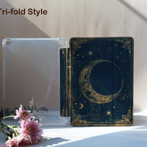 May include: A clear, tri-fold style tablet case and a dark blue tablet case with a celestial design featuring a crescent moon, stars, and gold accents. The text "Tri-fold Style" is at the top. Pink flowers are in the foreground.