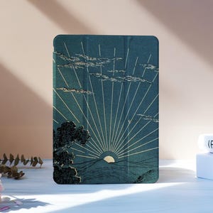 May include: A teal tablet case featuring a sunrise over water with a tree silhouette. The design includes white rays emanating from the sun, clouds, and a textured appearance. The case is rectangular with rounded corners.