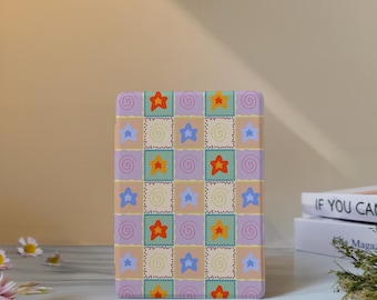 May include: A rectangular item with a patchwork design. The design features squares in various colours, including tan, lavender, and green, each containing stars and spiral details. The stars are in shades of orange, yellow, and blue.