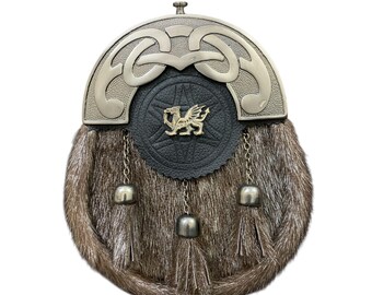 May include: A traditional Scottish sporran with a silver cantle and fur body. The sporran features a black leather flap with a gold emblem and decorative chains with silver bell-shaped tassels. The fur is a mix of brown and grey.
