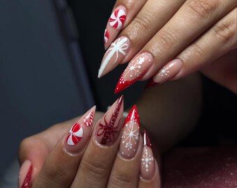 Uñas navideñas con purpurina roja y diseño de bastón de caramelo