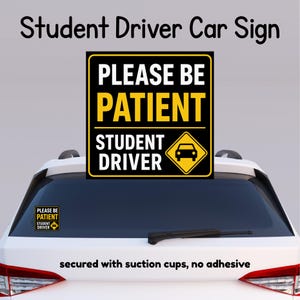 May include: A black and yellow square car sign with the text PLEASE BE PATIENT STUDENT DRIVER and a car icon. The sign is displayed on the rear window of a white vehicle and is secured with suction cups, featuring no adhesive backing.
