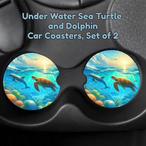 May include: Set of two car coasters featuring an underwater scene with a dolphin, sea turtle, and coral. The coasters have a vibrant design with blue, yellow, and green hues, and the text "Under Water Sea Turtle and Dolphin Car Coasters, Set of 2".