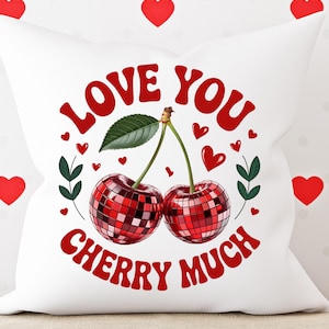 May include: White decorative pillow with a red cherry design. The design includes two cherries with a disco ball effect, green leaves, and the text "LOVE YOU CHERRY MUCH" in red. Red hearts are scattered around the pillow.