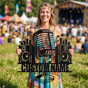 Puede incluir: Letrero de metal negro con un micrófono, altavoces y notas musicales. El letrero incluye el texto "CUSTOM NAME". El fondo muestra un festival de música con una multitud y un escenario.