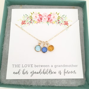 Puede incluir: Collar de oro con tres peque&ntilde;os colgantes, cada uno con un cristal de color diferente: azul claro, azul oscuro y &aacute;mbar. El collar est&aacute; en una caja con una tarjeta que dice: "EL AMOR entre una abuela y sus nietos es para siempre."