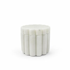 May include: A cylindrical white marble container featuring a scalloped, fluted exterior design. The object consists of a base and a matching removable lid, both crafted from solid stone with a smooth, matte finish and subtle natural veining.