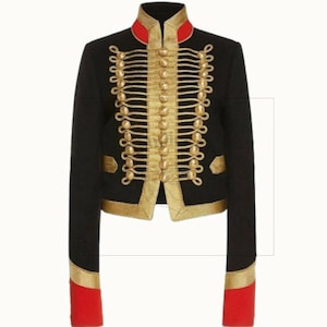 May include: Black cropped jacket with gold trim and detailing. The jacket has a high collar with red accents, gold rope-like embellishments, and red cuffs. A military-style design.