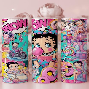 May include: Three colorful tumblers featuring Betty Boop designs. One tumbler has the word "WOW" in a speech bubble, another has Betty Boop blowing a bubble, and the third has Betty Boop with a lollipop. The tumblers are decorated with vibrant colors and cartoon imagery.
