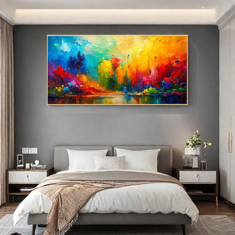 May include: A vibrant abstract landscape painting with a gold frame. The artwork features a colorful array of blues, greens, yellows, and reds, depicting a waterside scene. The painting is displayed above a bed in a bedroom setting.