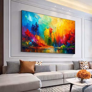 May include: A large, rectangular abstract painting with a vibrant color palette of blues, greens, yellows, oranges, and reds. The artwork depicts a landscape with trees and a body of water, creating a colorful and dynamic scene. The painting is framed and mounted on a white wall.