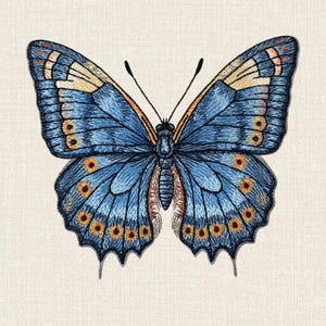 Op de afbeelding: Een geborduurde vlinderpatch in tinten blauw, beige en oranje. De vleugels tonen ingewikkeld draadwerk met een reeks kleine oranje cirkelvormige patronen langs de randen, een donker centraal lichaam en twee dunne zwarte voelsprieten.