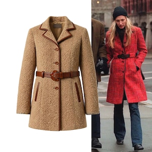 May include: A tan textured coat with brown trim and a matching belt. The coat has a classic design with a notched collar, button closure, and front pockets. The belt cinches the waist, creating a flattering silhouette. A red coat with a black belt is also shown.