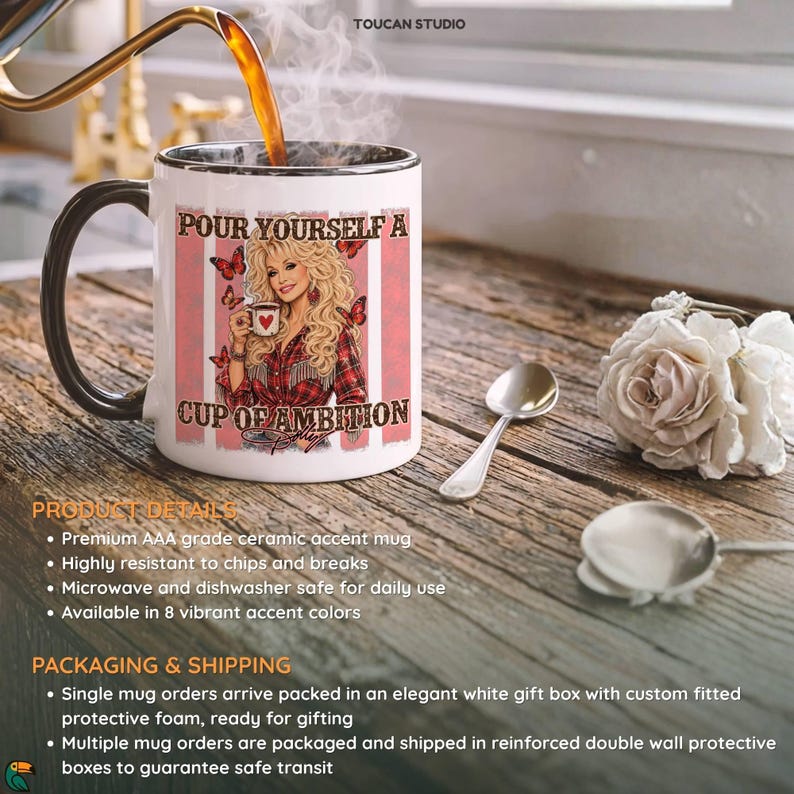 May include: A white ceramic mug with a black handle and interior rim. The mug features a graphic of a blonde woman in a red plaid shirt holding a cup, surrounded by butterflies and the text, Pour Yourself A Cup Of Ambition, with pink stripes.