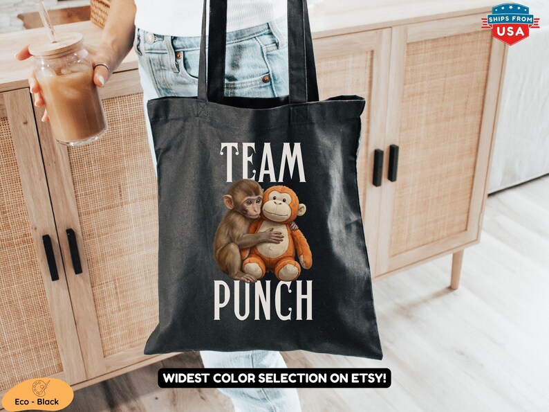 May include: Black tote bag featuring the words "TEAM PUNCH" in white, with an illustration of two hugging monkeys. The bag is held by a person. The words "WIDEST COLOR SELECTION ON ETSY!" are at the bottom.