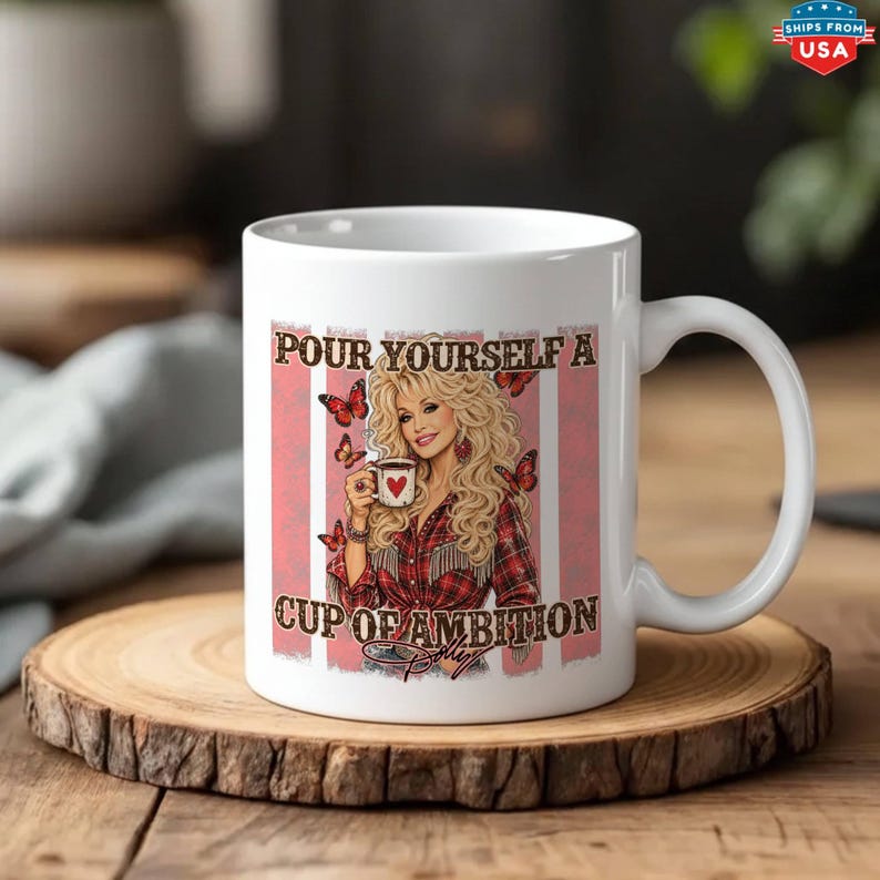 May include: A white ceramic mug featuring a graphic of a blonde woman in a red plaid shirt holding a small mug with a red heart. The design includes red butterflies and the text "POUR YOURSELF A CUP OF AMBITION" in a dark brown script font.