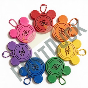 May include: A collection of seven circular keychains in red, orange, yellow, green, blue, purple, and pink. Each keychain features a Mickey Mouse-inspired silhouette with a central cutout design and a matching coloured ball chain attachment.