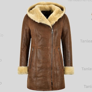May include: A brown leather coat with a hood and a cream-coloured shearling lining. The coat has a zip closure, two front pockets, and shearling cuffs. The coat is a mid-length style.