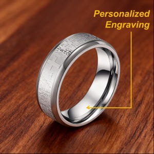 K&ouml;nnte beinhalten: Ein silberfarbener Ring mit Gravur und Kreuzdesign. Der Ring hat eine polierte Oberfl&auml;che, und im Bild steht der Text "Personalized Engraving".
