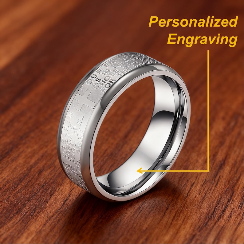 K&ouml;nnte beinhalten: Ein silberfarbener Ring mit Gravur und Kreuzdesign. Der Ring hat eine polierte Oberfl&auml;che, und im Bild steht der Text "Personalized Engraving".