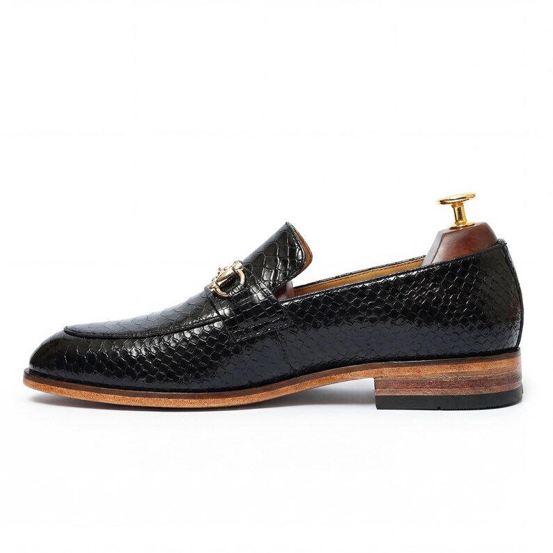 Side profile of mens dress loafers on wooden shelf Leathersmerchant