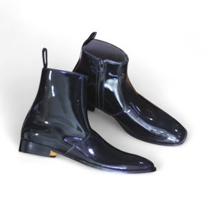 Side View: Side profile showcasing sleek patent leather finish and side zipper for a modern twist on classic ankle boots.