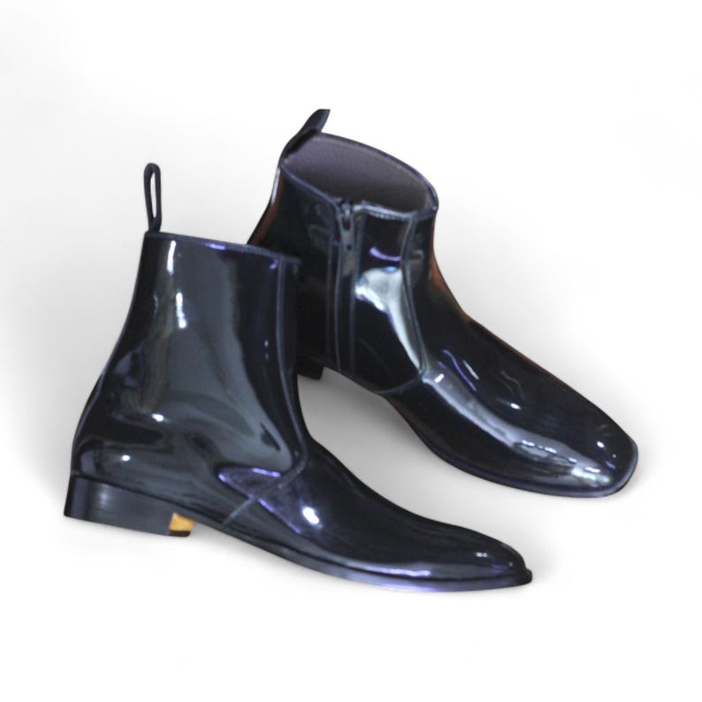 Side View: Side profile showcasing sleek patent leather finish and side zipper for a modern twist on classic ankle boots.