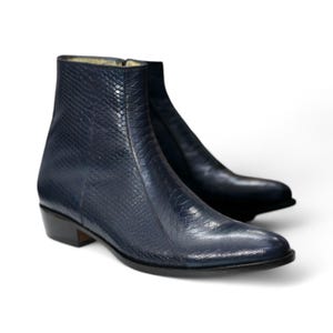 Side profile of black python leather boots highlighting full-length zipper, ankle fit, and motorcycle-ready design.