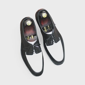 Front view of handmade black & white leather derby shoes with classic lace-up design, perfect for formal occasions.