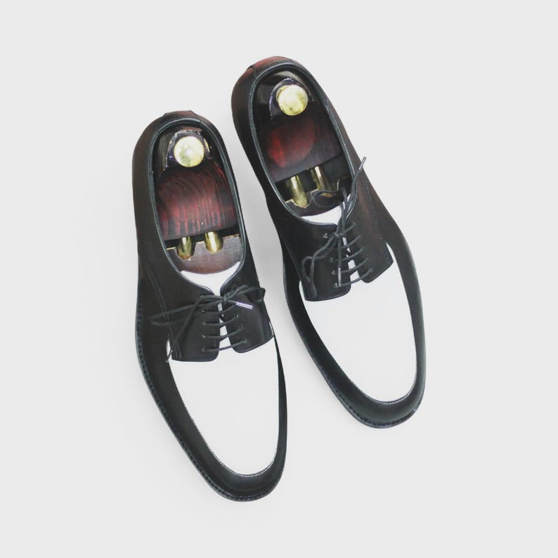Front view of handmade black & white leather derby shoes with classic lace-up design, perfect for formal occasions.
