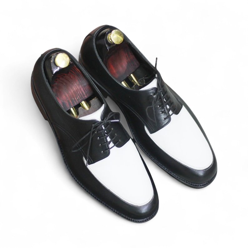 Front view of handmade black & white leather derby shoes with classic lace-up design, perfect for formal occasions.