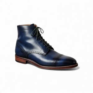 Front view of custom blue leather ankle boots with contrasting green laces