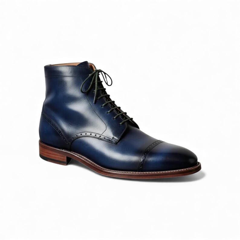 Front view of custom blue leather ankle boots with contrasting green laces