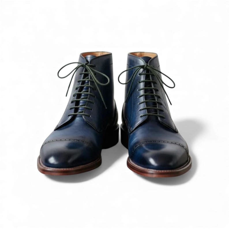 Close up of a single handmade leather dress boot with perforations.