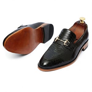 Side profile of mens dress loafers on wooden shelf Leathersmerchant